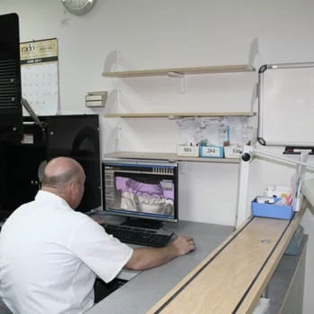 A Spectrum Dental Laboratories technician working at a CAD workstation