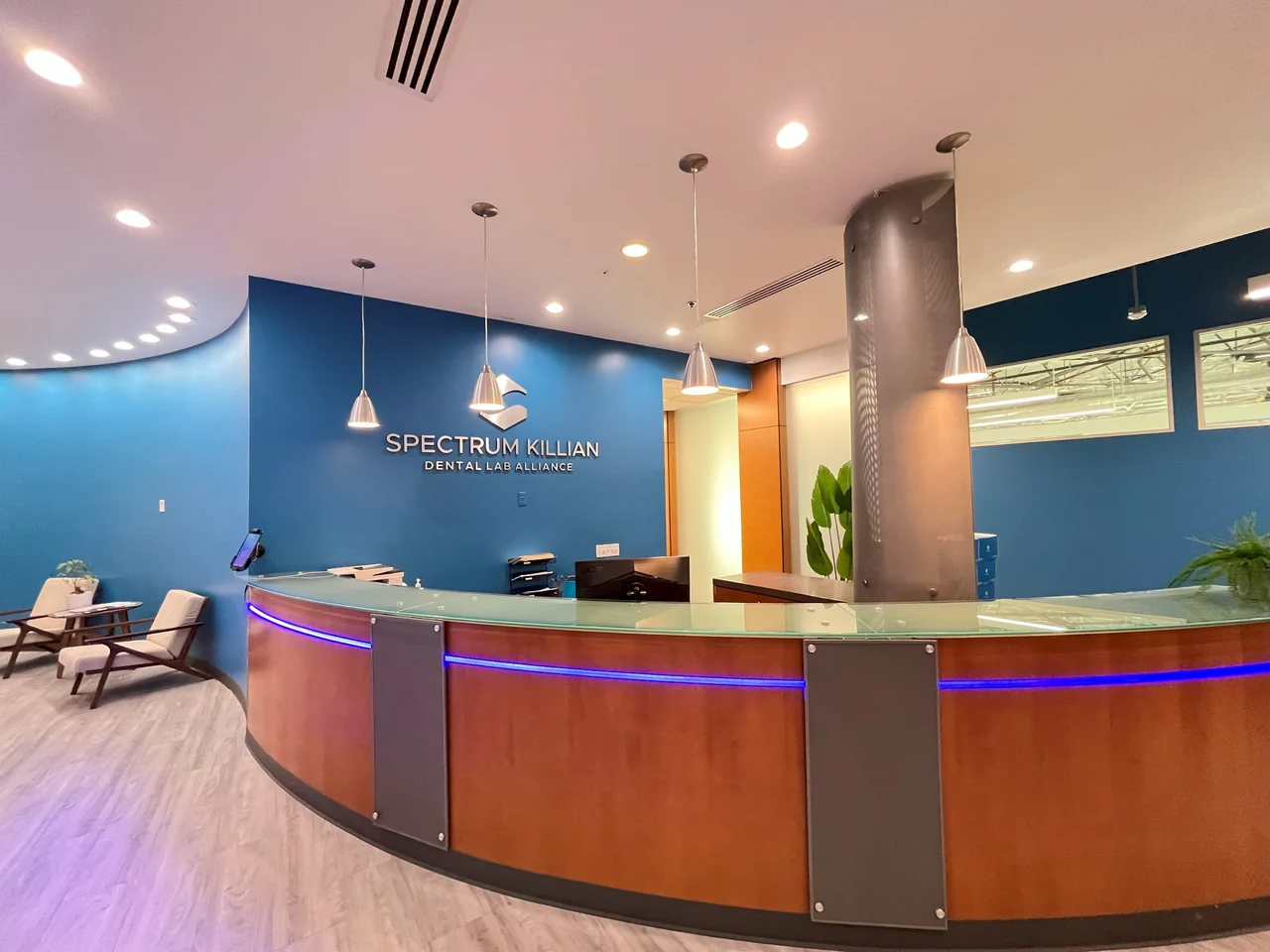 Front reception desk with the Spectrum Killian sign on a blue wall