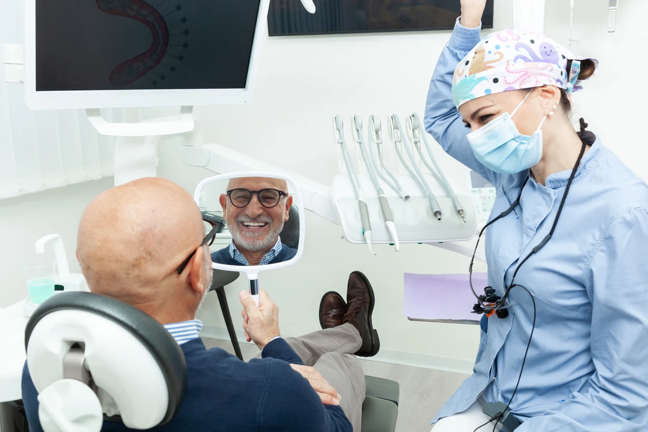 Dentist with a patient viewing his smile in a mirror
